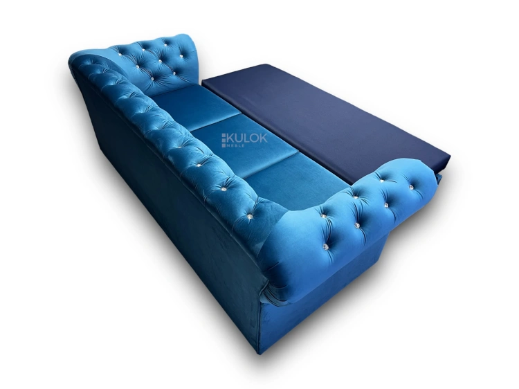 Niebieska sofa glamour chesterfield, pikowana welurem, rozkładana z funkcją spania.