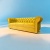 Trzyosobowa sofa pikowana z funkcja spania w żółtym welurze.