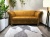 Nowoczesna sofa do salonu w stylu skandynawskim na wysokich nogach orzech w imitacji skóry. Salon nowoczesny loft.